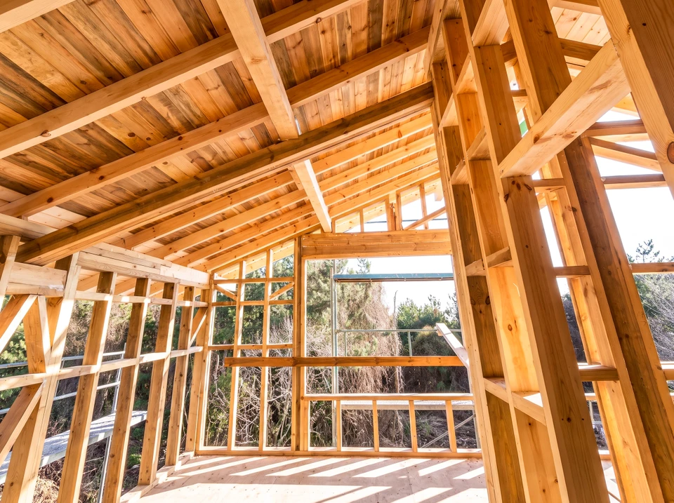 Intérieur d'une ossature bois en cours de construction, vue depuis le rez-de-chaussée
